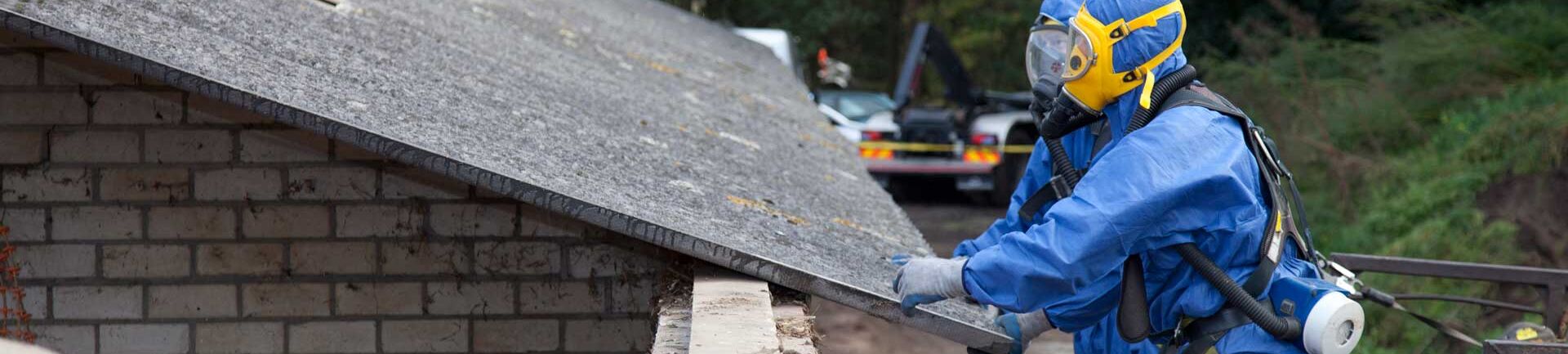 Das Bild für Asbest Sachkunde zeigt zwei Arbeiter in Schutzanzügen und Atemmasken, die ein Dach inspizieren.