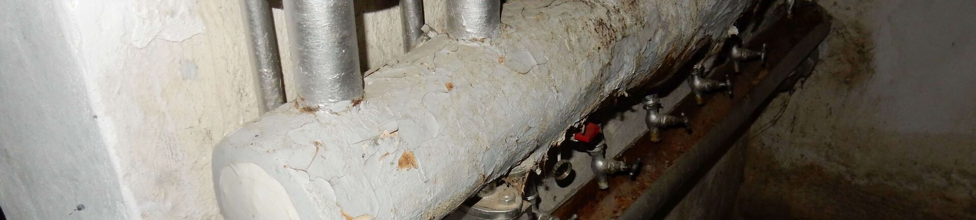 Das Bild für den großen Asbestschein zeigt Rohrleitungen, die eine Sanierung brauchen.